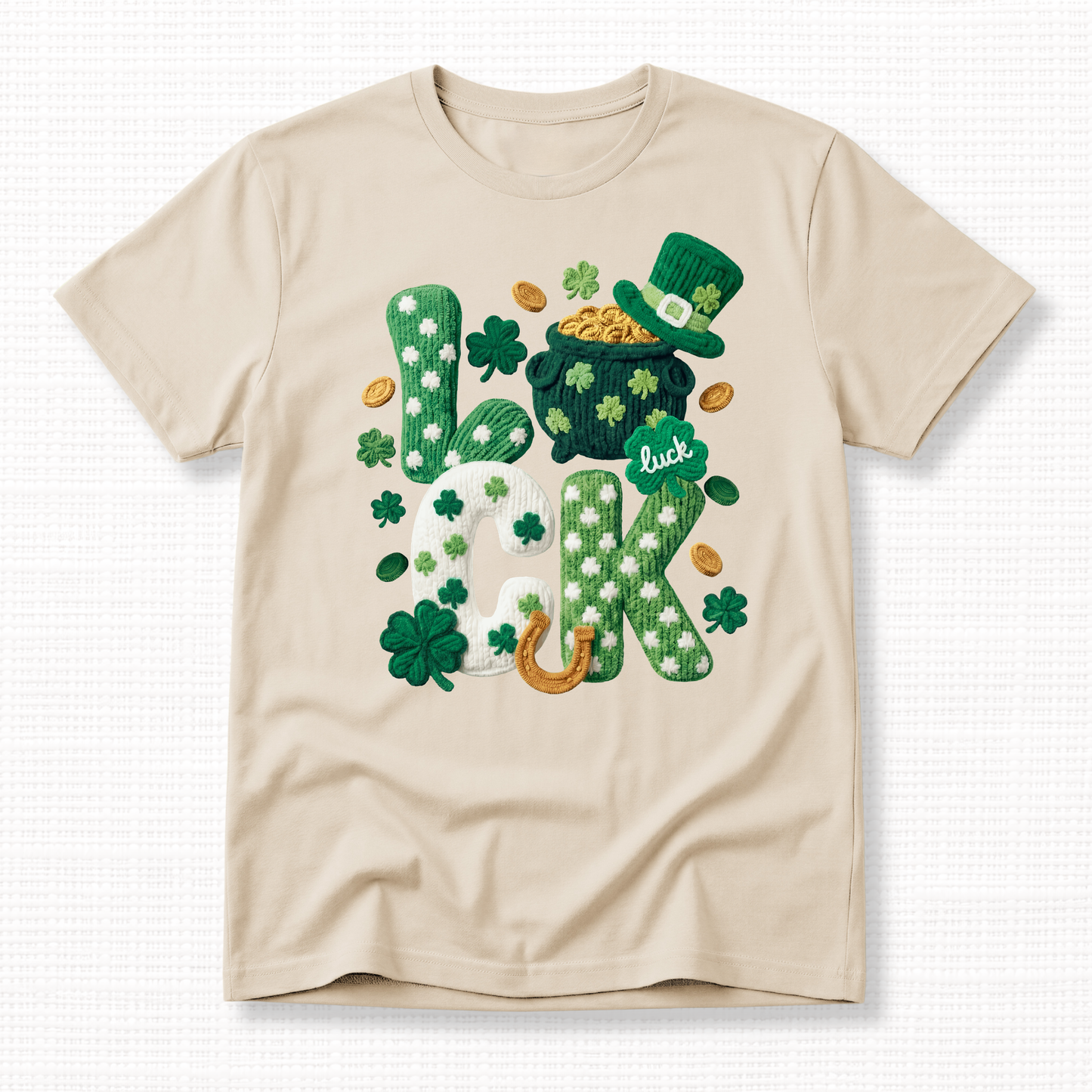 St. Patrick’s Day t-shirt with textured “Lucky” shamrock lettering, pot of gold, leprechaun hat, and horseshoe on a sand t-shirt.