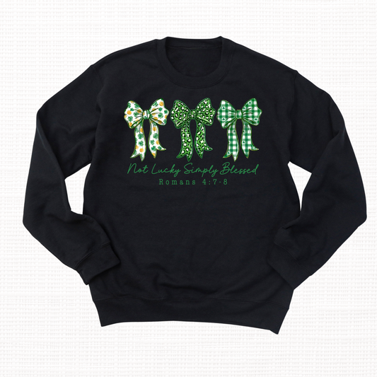 Black crewneck sweatshirt with three green bows and the phrase “Not Lucky Simply Blessed” with Romans 4:7-8