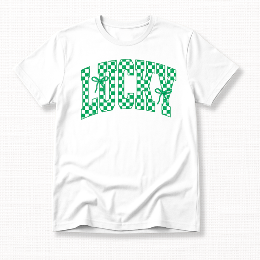 White t-shirt with green and white checkered “Lucky” lettering and ribbon bows