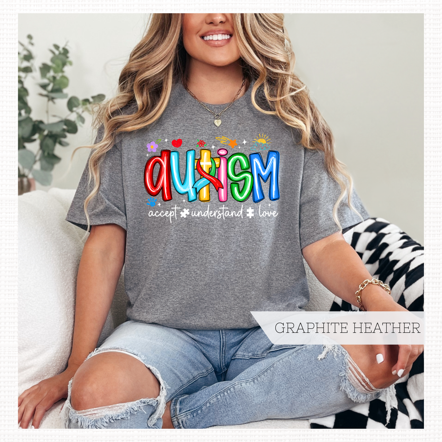 Person wearing a gray shirt with colorful 'Autism' text and words 'Accept, Understand, Love' underneath in black.