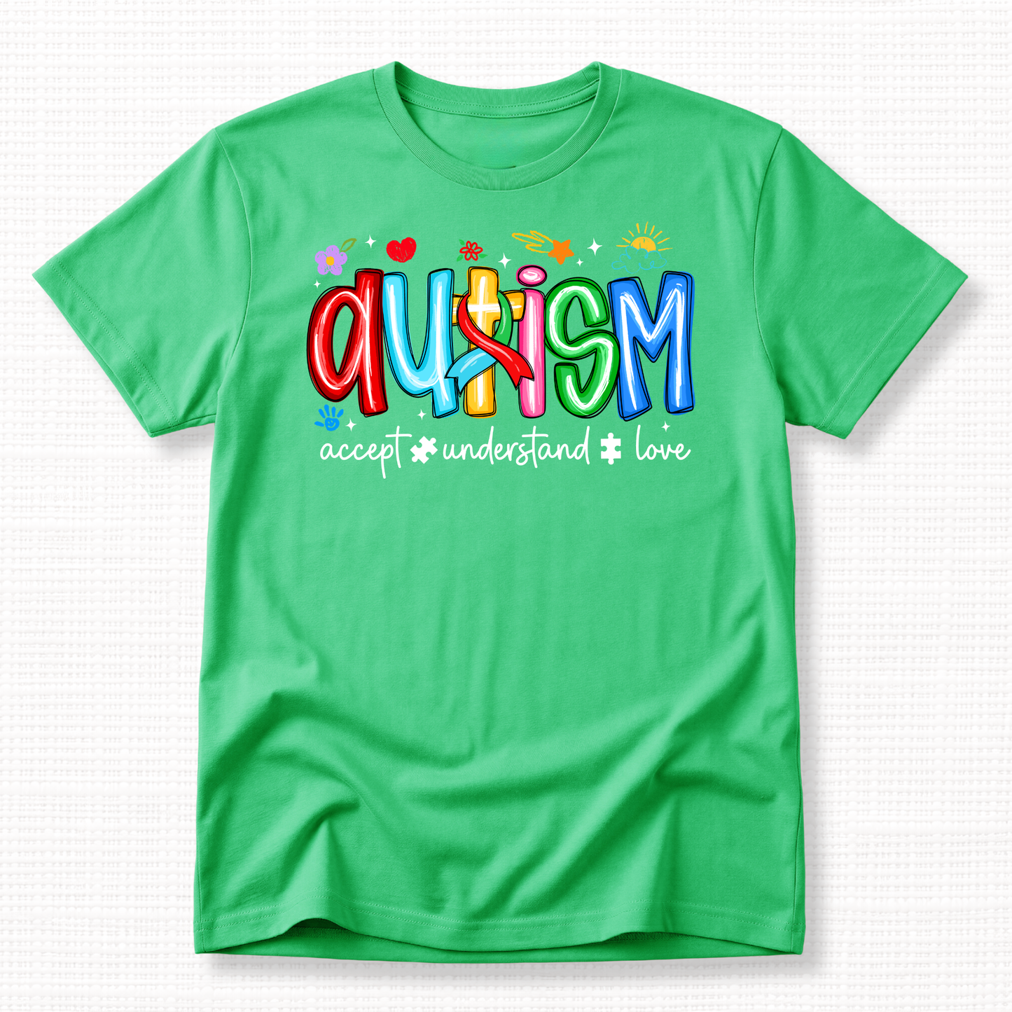 A green shirt with colorful 'Autism' text and words 'Accept, Understand, Love' underneath in white.
