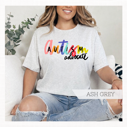 Person wearing ash grey t-shirt with 'Autism advocate' text in colorful letters.
