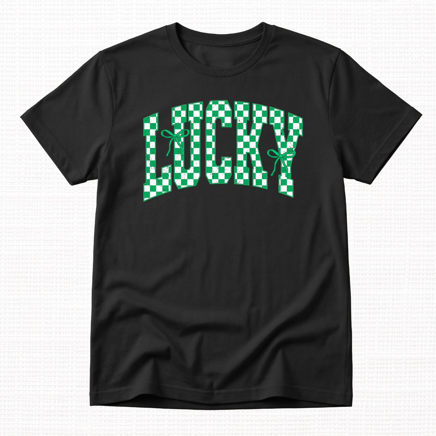 Black t-shirt with green and white checkered “Lucky” lettering and ribbon bows